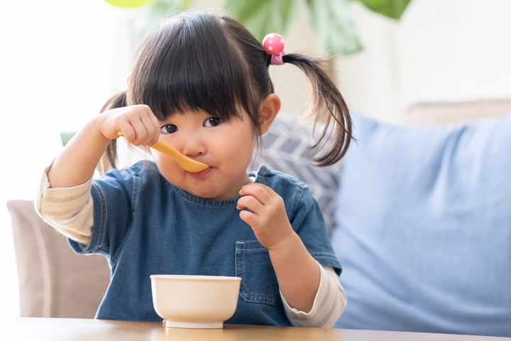 Photo of a young person eating from a bowl